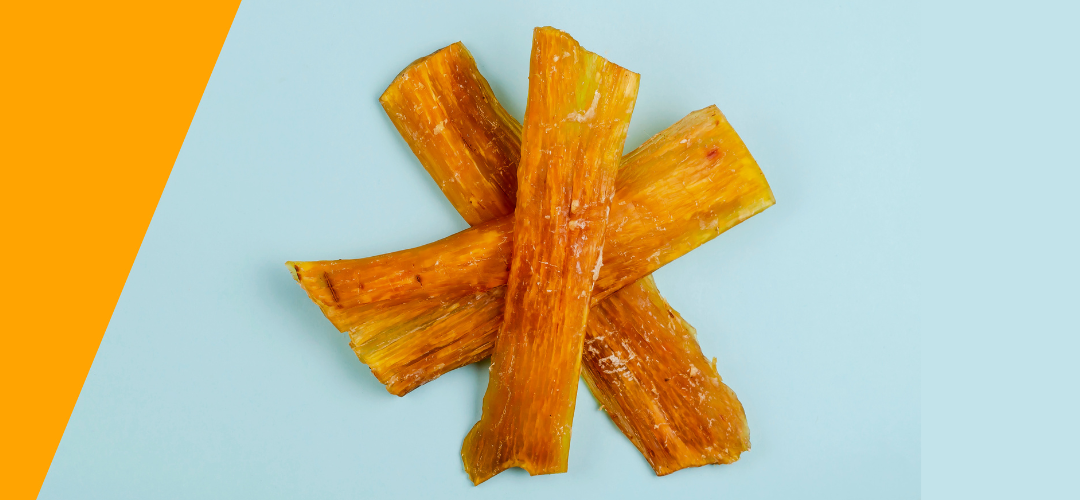 large dog looking inside with nose poked inside bag of beef tendons